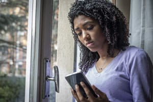 sad young woman looking hurt by message on phone  
