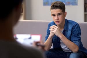 Young man talking in therapy, opening up, confiding