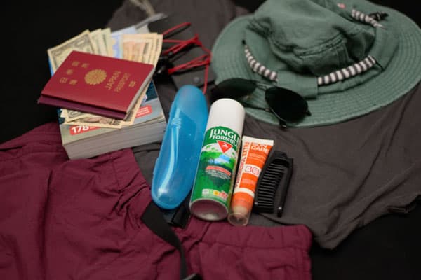 Travel essentials, including passports, clothes and sun protection ready to be packed.